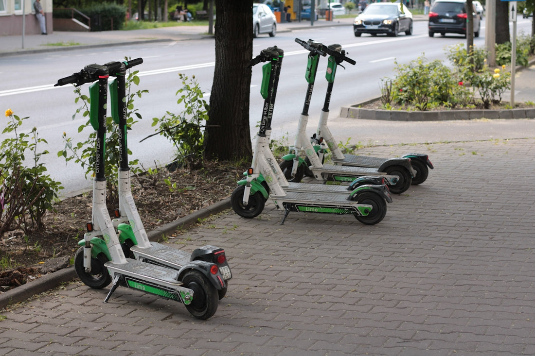 three green and white scooters parked on the side of the road